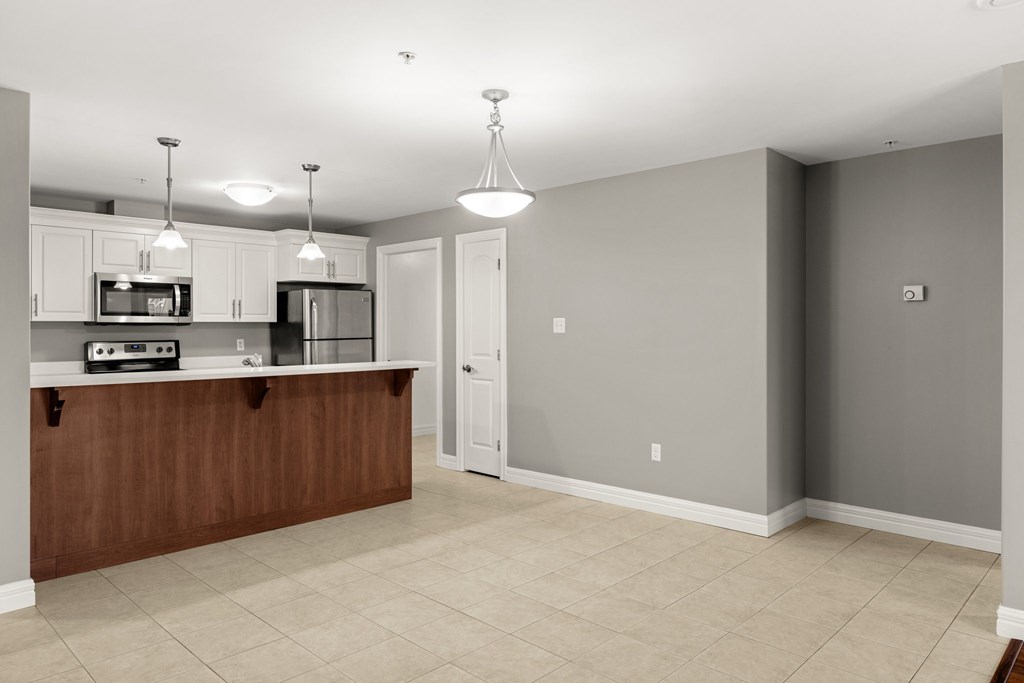 A kitchen with a microwave, oven, and cabinets.