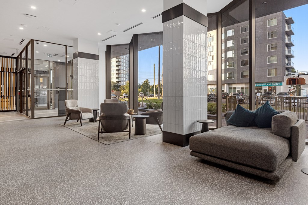 a living room with a couch and chairs in front of glass doors