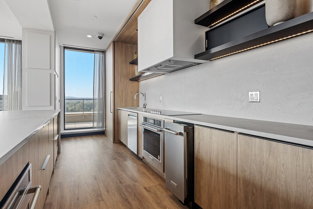 a kitchen with wooden cabinets and white appliances and a sliding glass door