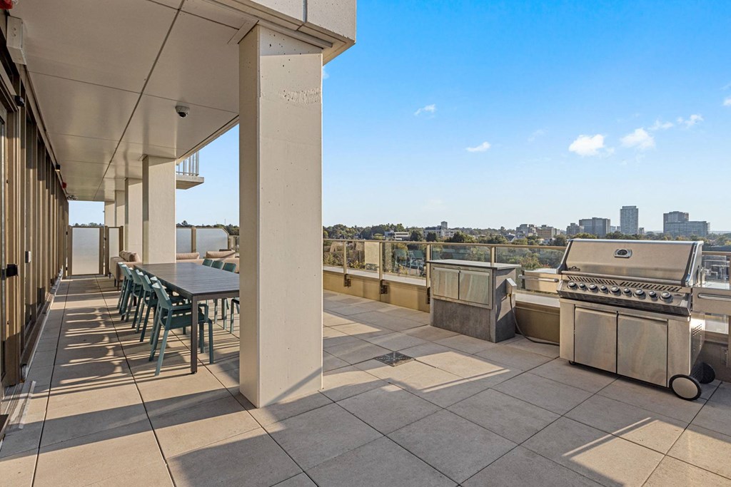 the deck has a grill and a table with chairs on it