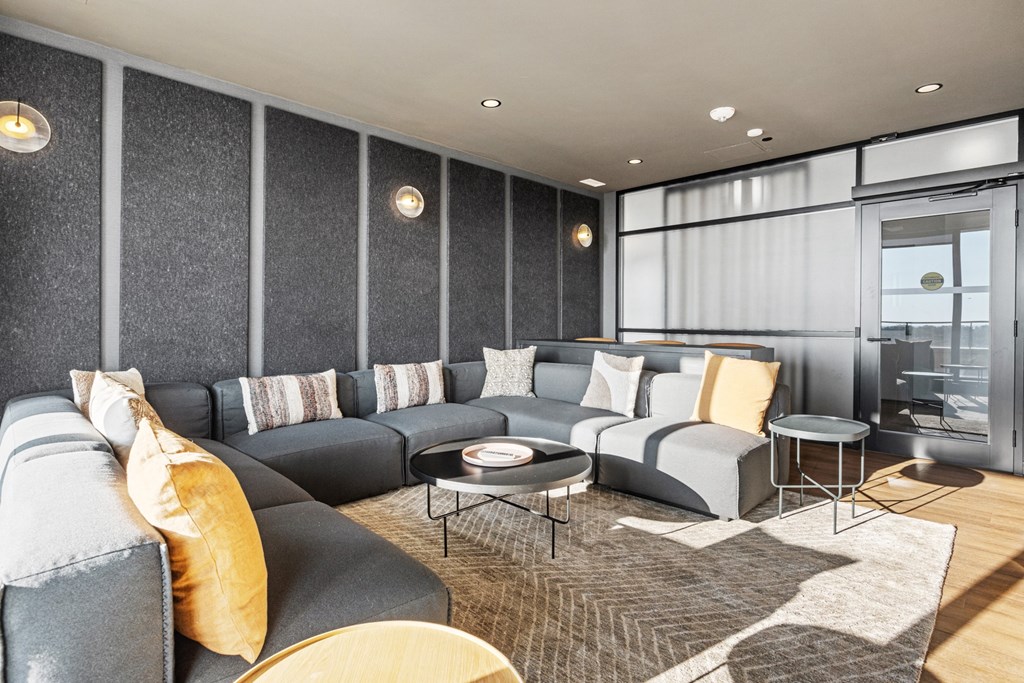 a living room with grey couches and a rug