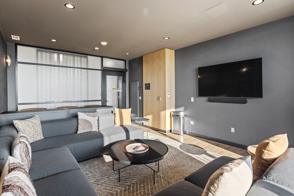 a living room with a gray couch and a television