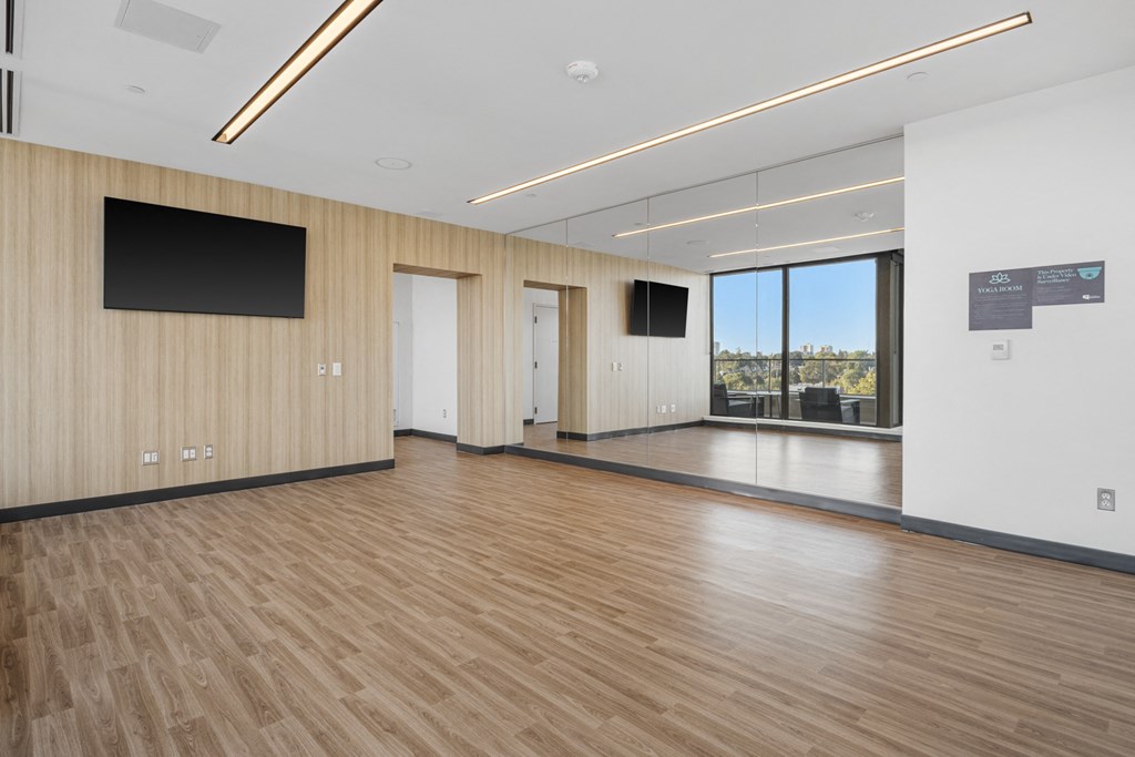a large room with wood flooring and a large window