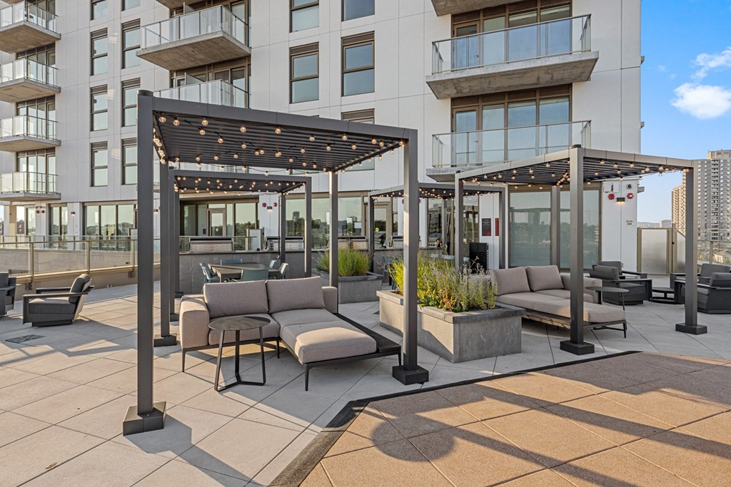 an outdoor patio with couches and tables in front of a building