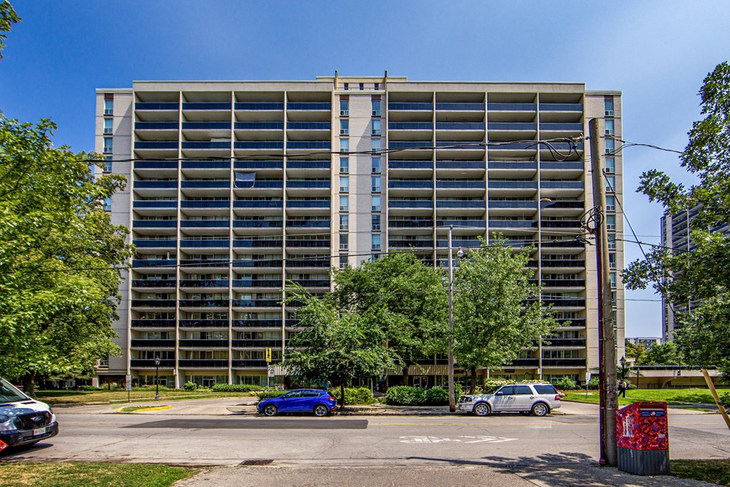 A tall building with a parking lot in front of it.