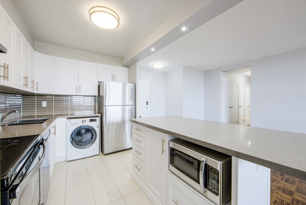 A kitchen with white cabinets and appliances.