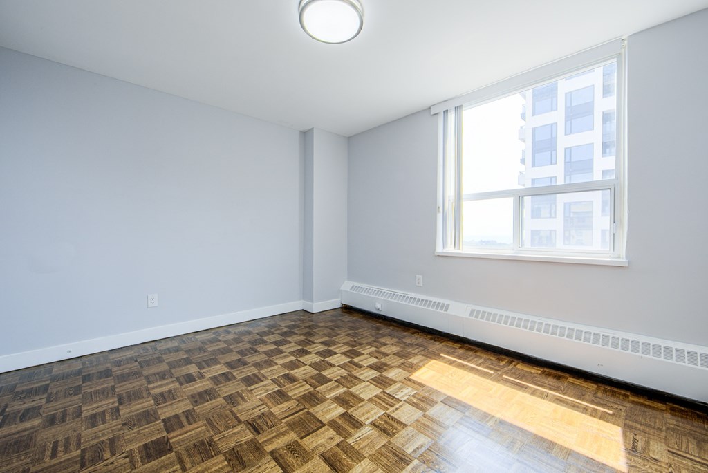 A room with a window and a wooden floor.