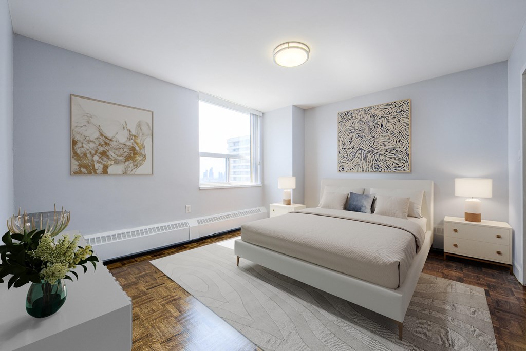 A bedroom with a large bed, a vase of flowers, and a painting on the wall.