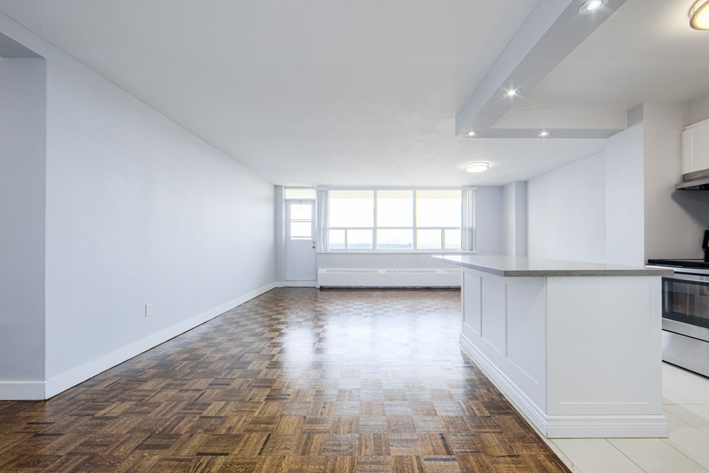 A kitchen with a wooden floor and white walls.