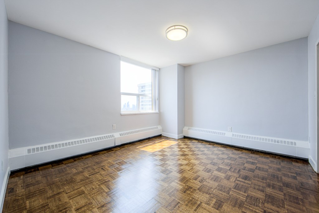 A room with wooden flooring and white walls.