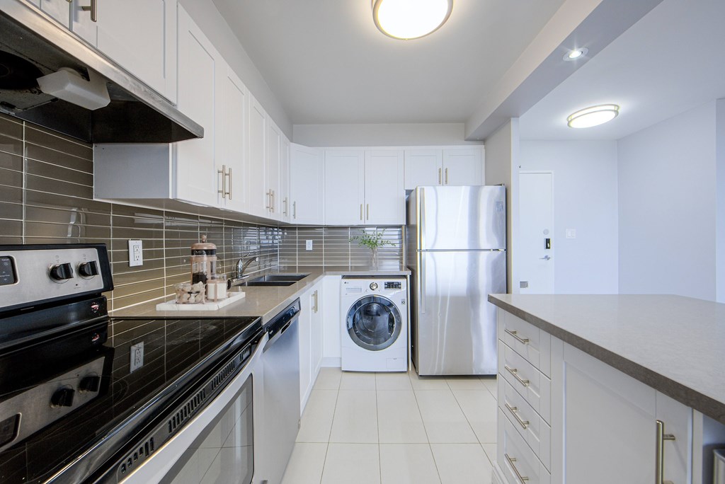 A modern kitchen with a black stove top oven and a stainless steel dishwasher.