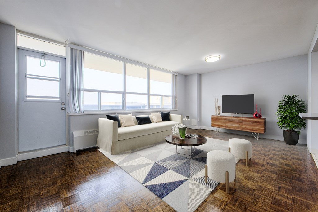 A living room with a white couch, a coffee table, and a television.