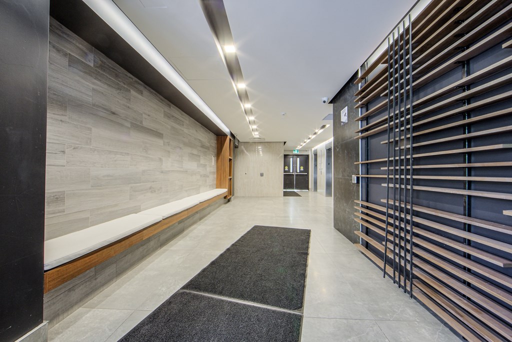 A hallway with a black and white rug in the middle.