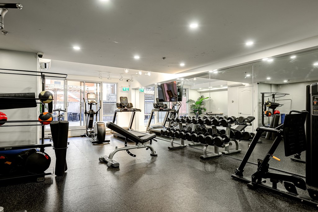 A gym with a variety of equipment including weights and machines.