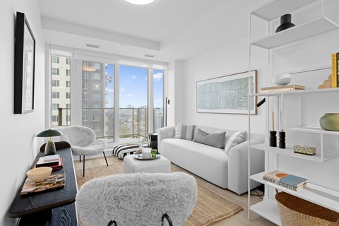 A living room with a white couch and a large window.