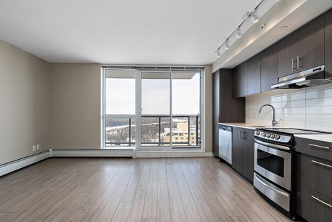 A kitchen with a stove top oven and a window overlooking the city.