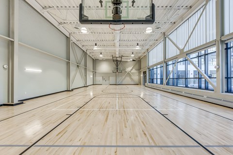A large, empty gymnasium with wooden floors and a high ceiling.