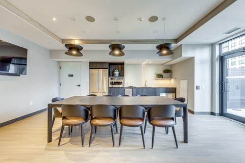 A modern dining room with a large table and chairs.