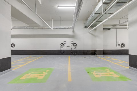 Two parking spaces with green and white signs on the floor.