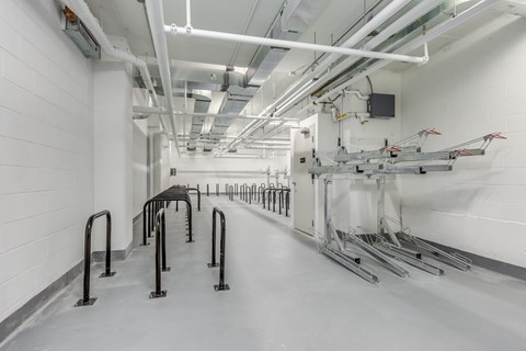 A long hallway with a row of black handles on the left and a row of white machines on the right.