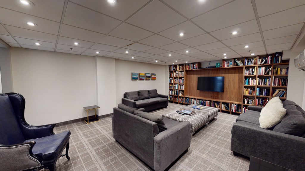 Library room with large book shelf, TV, and a seating area