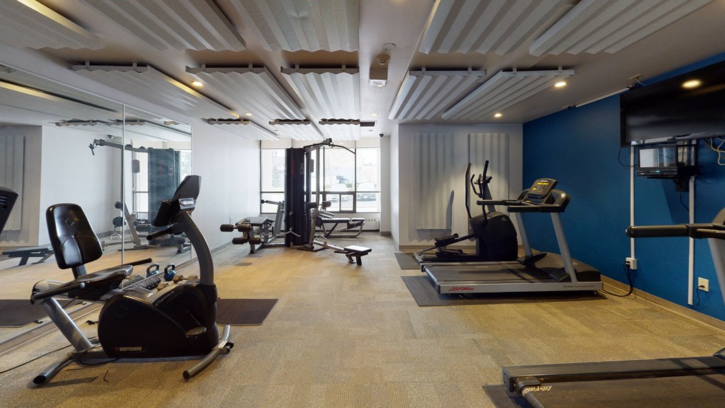 a gym with exercise equipment and a blue wall