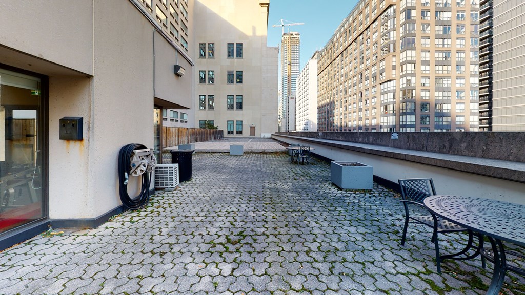 a patio with a table and chairs on the side of a building