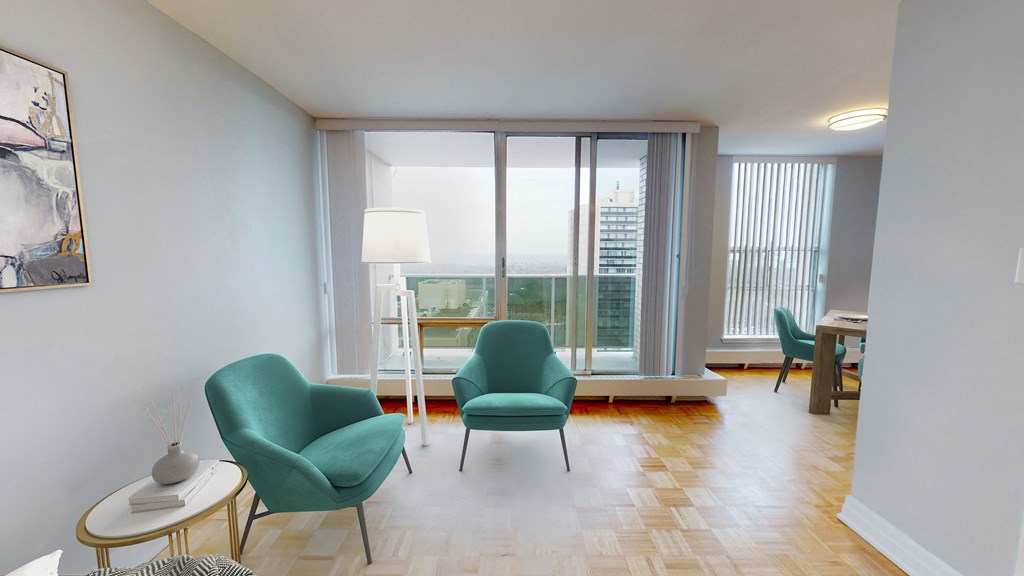 a living room with green chairs and a large window