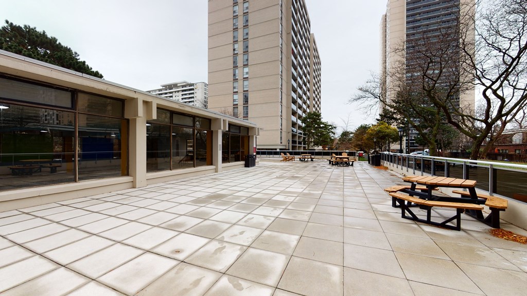 a large terrace with benches and buildings in the background