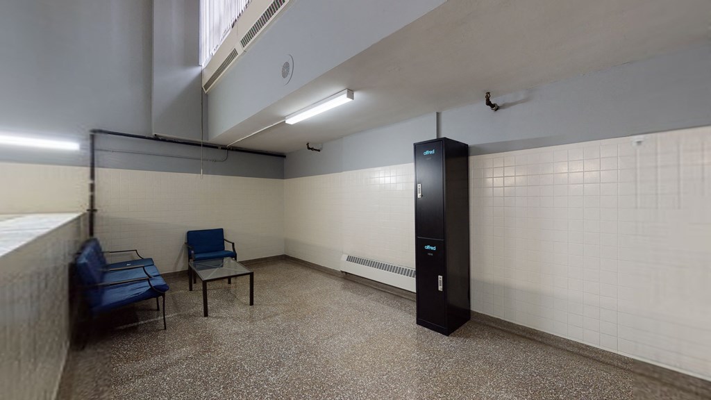 a room with a black refrigerator and two blue chairs