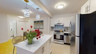 a kitchen with white cabinets and a table with flowers
