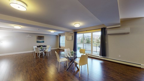 a dining room with a glass table and chairs and a large window
