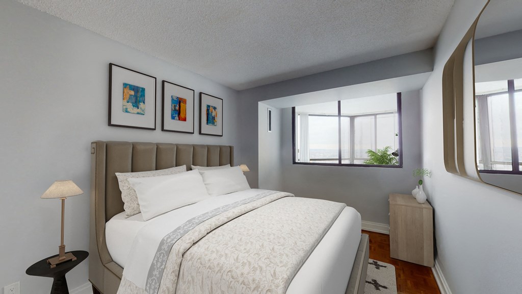 A bedroom with a large bed and a lamp on a side table.