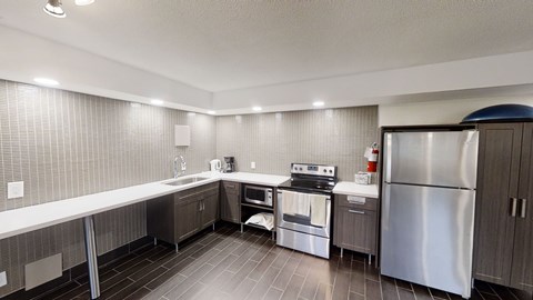 A modern kitchen with stainless steel appliances and a refrigerator.