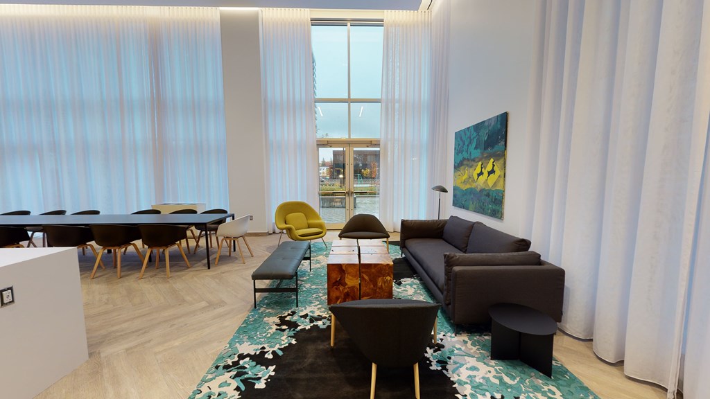 A room with a long table, chairs, and a painting on the wall.