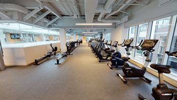 A gym with a row of exercise bikes.