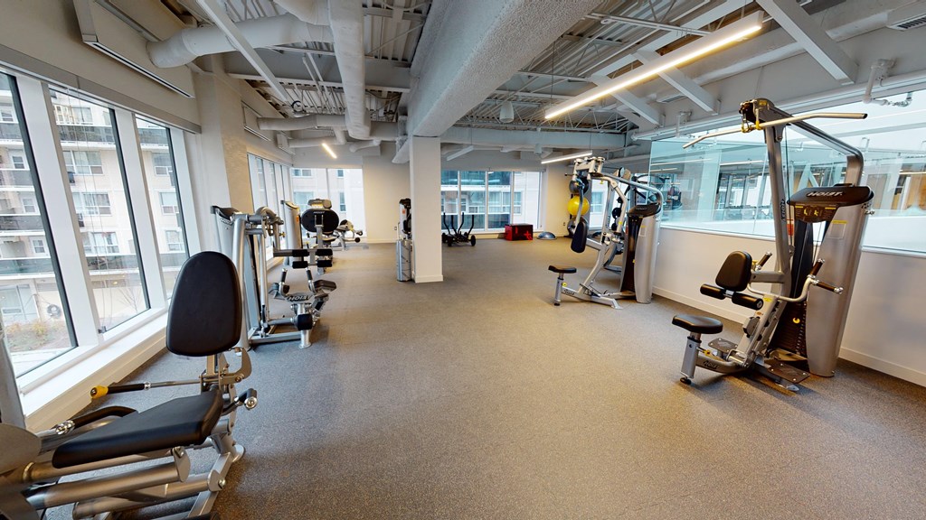 A gym with a variety of equipment including treadmills, weights, and exercise machines.