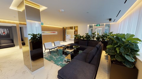 A living room with a grey couch and a large mirror.