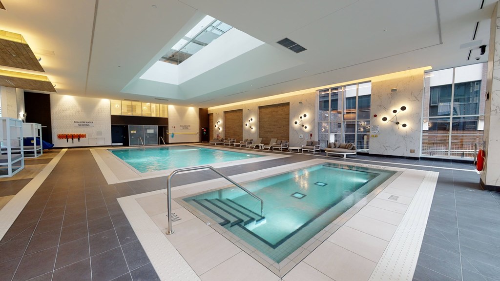 A large indoor swimming pool with a skylight above it.
