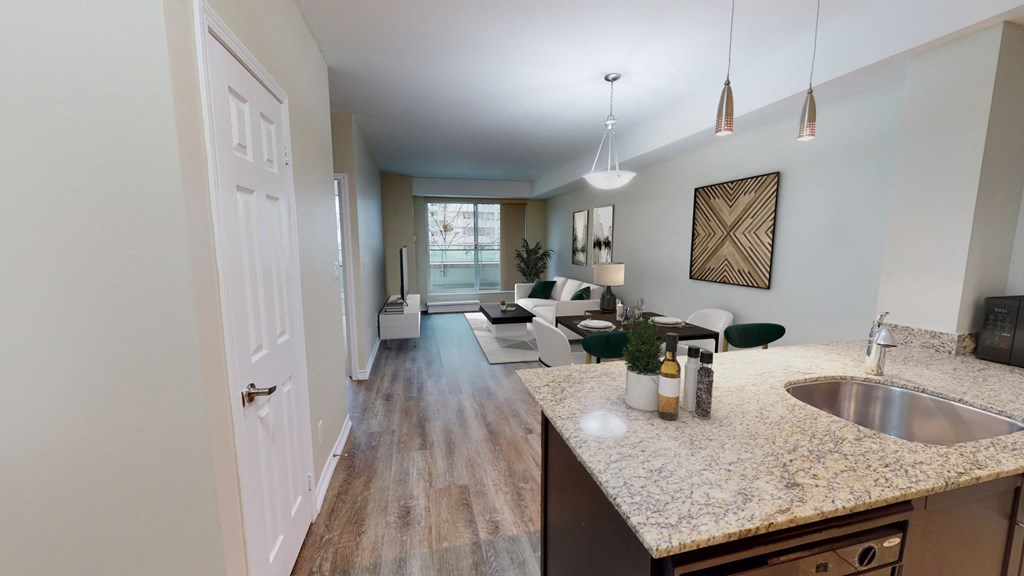 view of living room from kitchen with granite counter tops and living room with couches