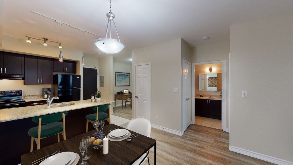 a dining room and kitchen area with a table and chairs