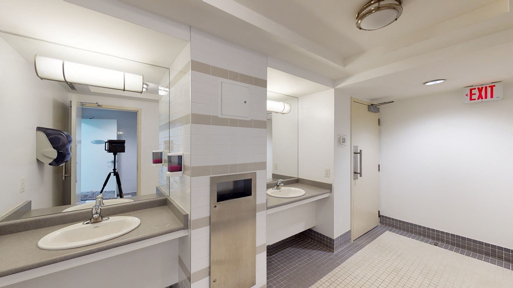 a public bathroom with two sinks and a mirror