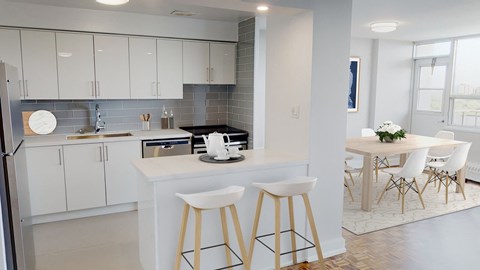 a kitchen and dining area with white cabinets and a counter top