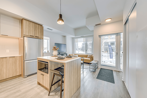 A kitchen with a refrigerator, oven, and sink.