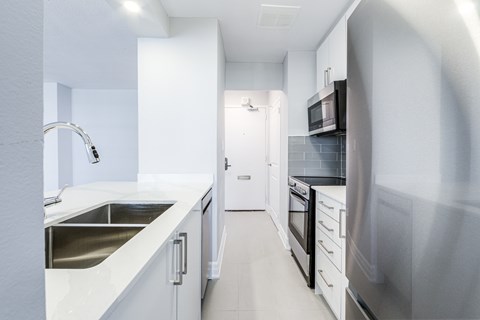 A modern kitchen with white cabinets and stainless steel appliances.