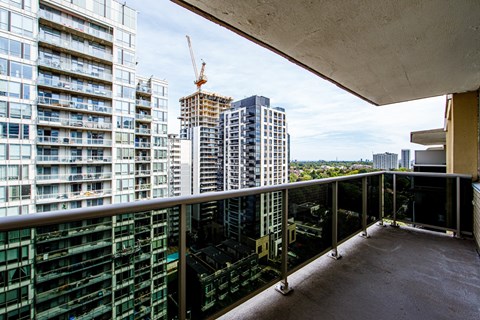 A balcony overlooks a cityscape with a crane in the distance.