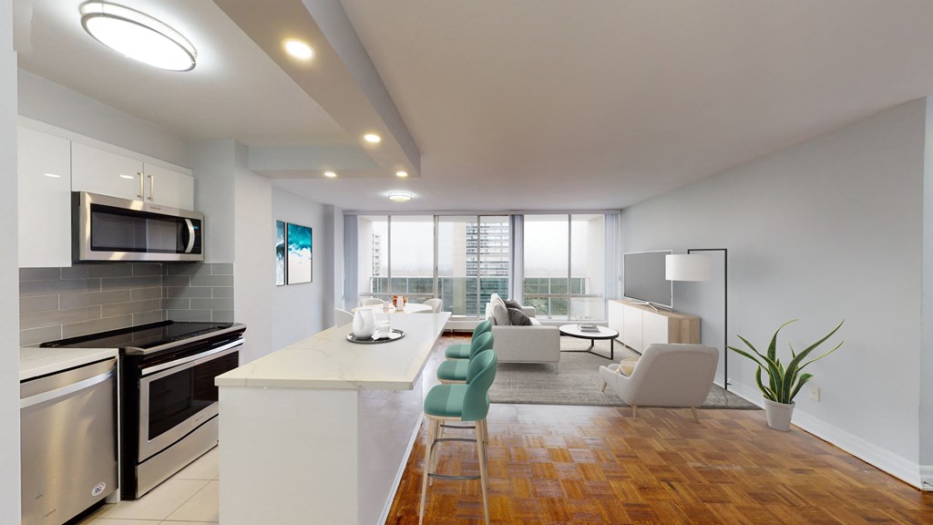 A modern kitchen with a white countertop and stainless steel appliances.
