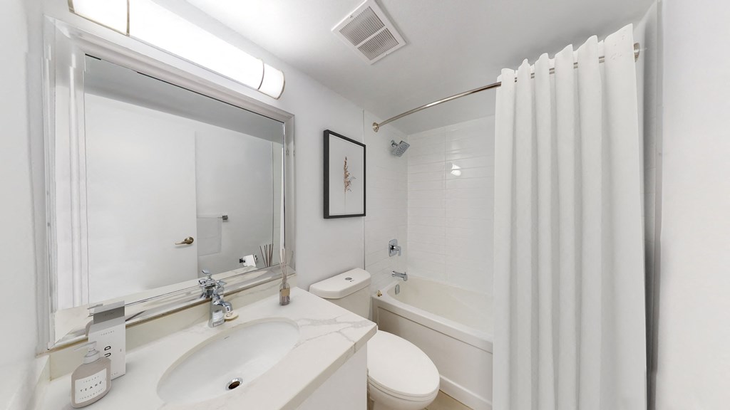 A white bathroom with a sink, toilet, and bathtub.