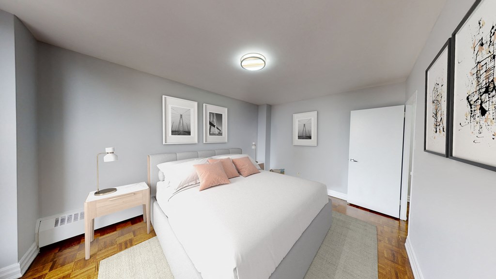 A bedroom with a bed, nightstand, and pictures on the wall.