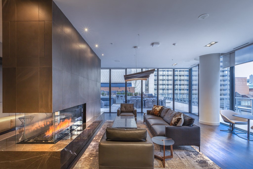 A modern living room with a fireplace and a view of the city.